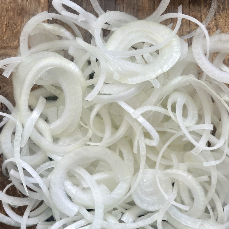 Image of Peel and slice the onion into 1/8” rounds, separating the rings and set aside.